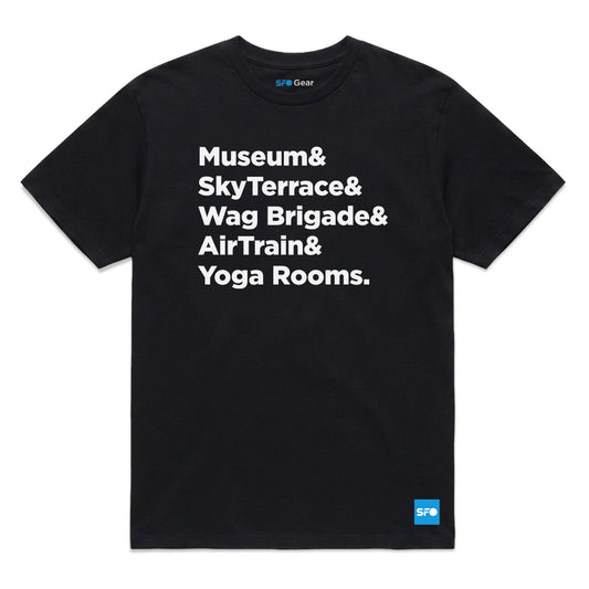 A black short-sleeve crewneck t-shirt with bold white text on the front reading 'Museum& SkyTerrace& Wag Brigade& AirTrain& Yoga Rooms.' A small blue SFO Gear logo is visible inside the collar and on the bottom right hem.